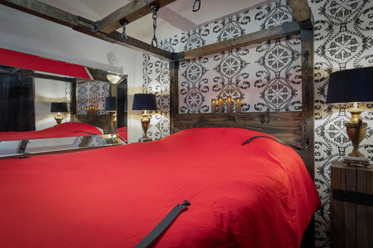 red intimate bedroom scene perfect for pleasure products companys pleasure pad to protect bedding.